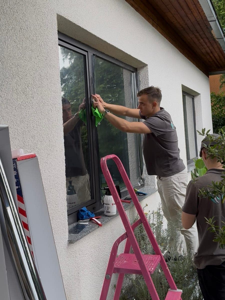 Monteur beim Anbringen der Folie an einem Hausfenster
