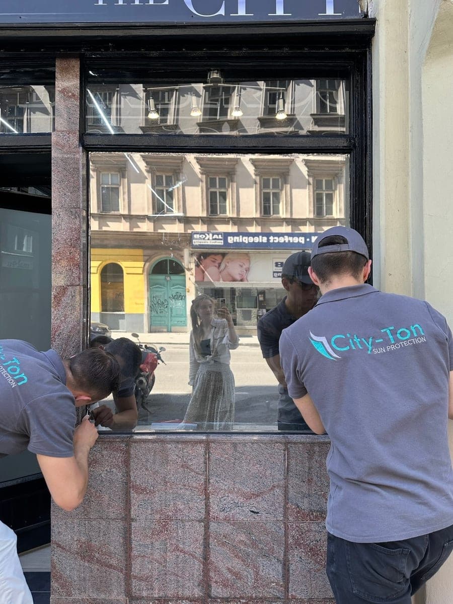 Zwei Monteure bei der Arbeit an einer Schaufensterscheibe