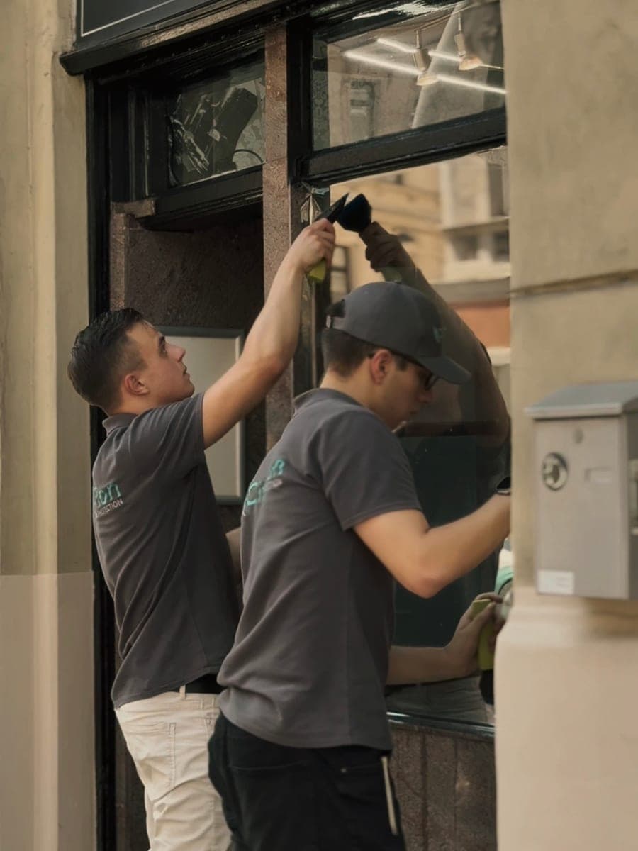 Zwei Monteure verkleben die Folie an einem Schaufenster